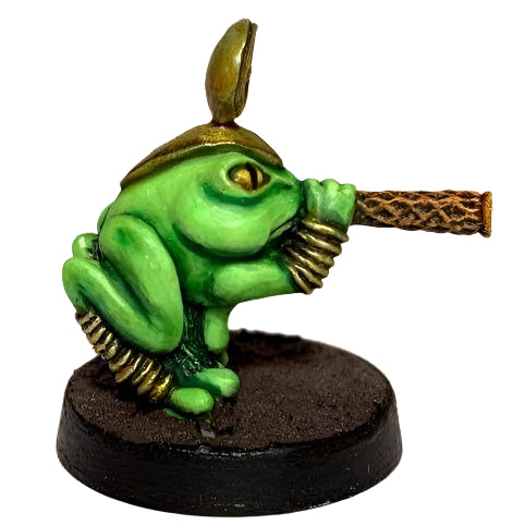 A miniature figure of a green frog with a golden blowpipe, designed for tabletop gaming.